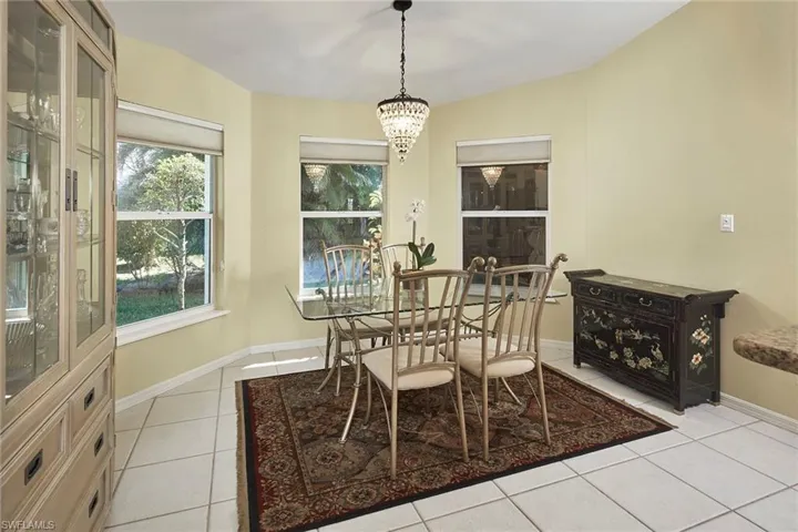 Dining room with light tile patterned floors and a chandelier
