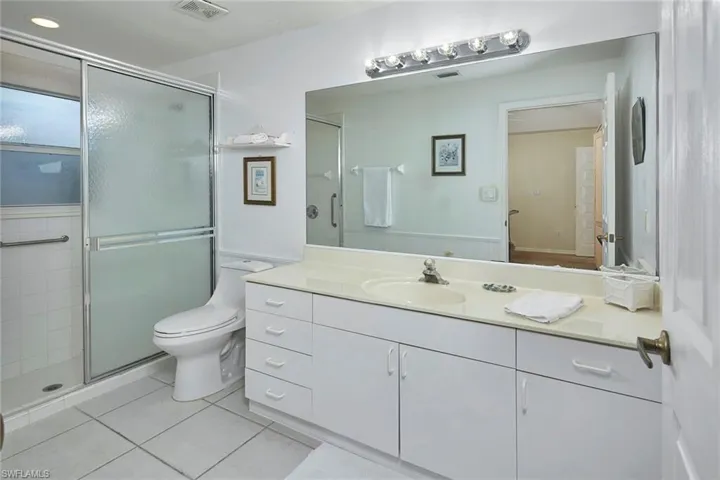 Bathroom featuring vanity, a stall shower, and light tile patterned flooring