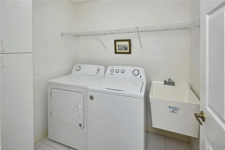 Laundry area with light tile patterned floors and washing machine and dryer