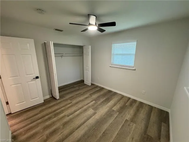Unfurnished bedroom featuring a closet, wood finished floors, and ceiling fan