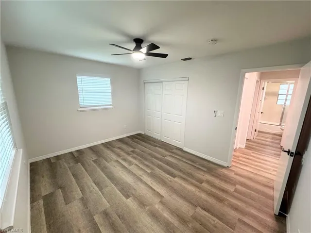 Unfurnished bedroom with light wood-style floors, a ceiling fan, and a closet
