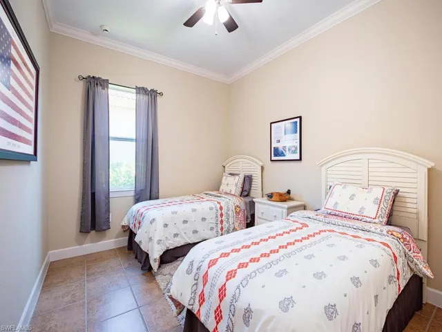 Tiled bedroom with crown molding and ceiling fan