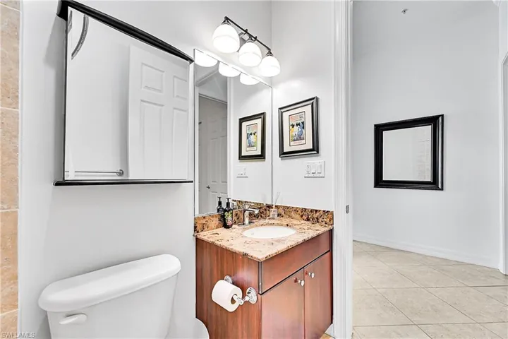 Bathroom with toilet, tile patterned floors, and vanity