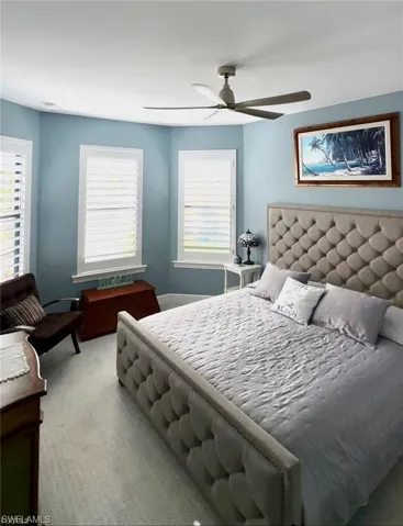 Bedroom with light carpet and a ceiling fan