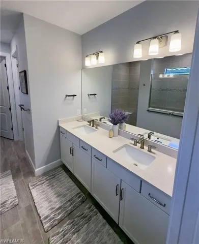 Bathroom with double vanity and wood tiled floors
