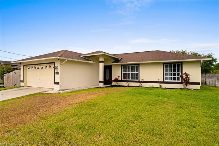 Ranch-style home featuring an attached garage, stucco siding, and driveway
