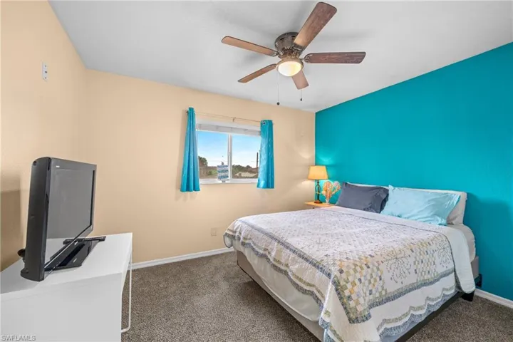 Bedroom featuring carpet floors, baseboards, and a ceiling fan