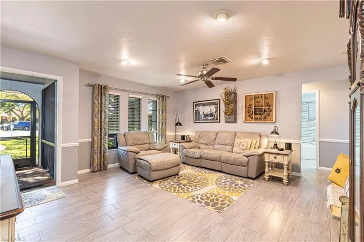 Living room featuring a textured ceiling, light hardwood / wood-style flooring, and ceiling fan