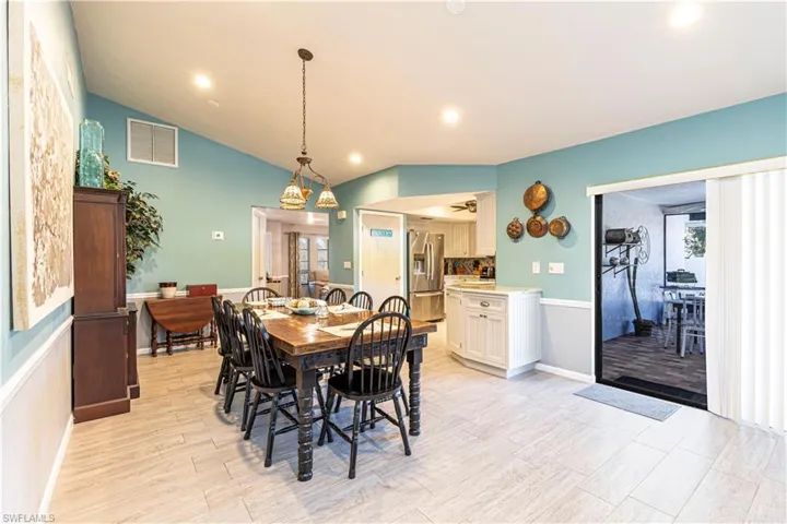 Dining space with light wood-type flooring and lofted ceiling
