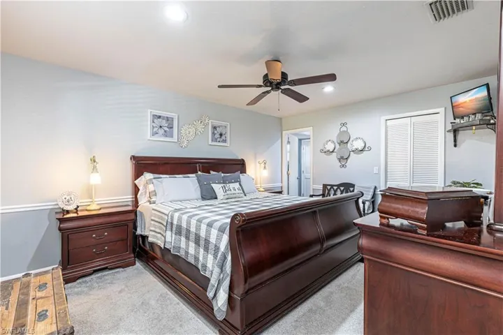 Master bedroom with walk-in closet and ceiling fan
