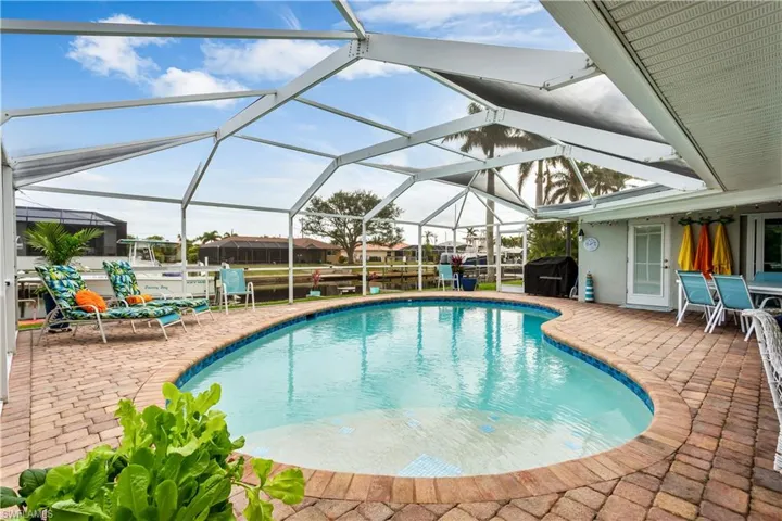 View of pool with a grill, a patio area, and a lanai