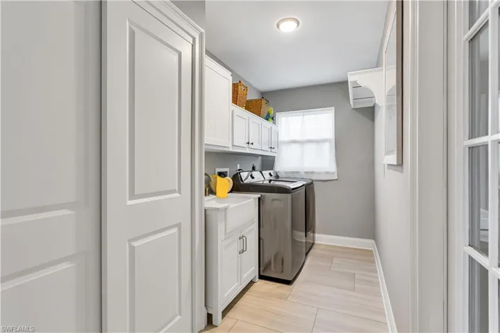Laundry area featuring washing machine and clothes dryer and cabinets