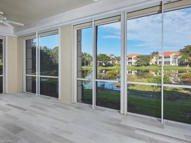 Spacious sunroom with peaceful pond views and pull-down hurricane storm shutters.