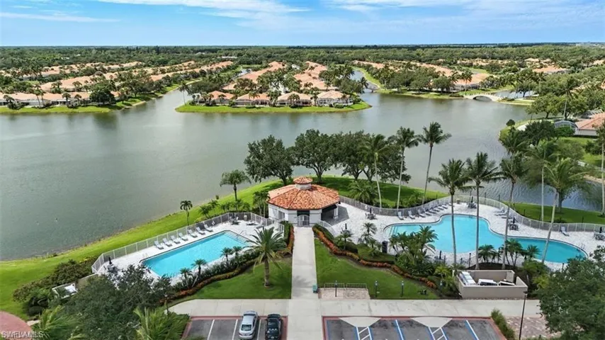Aerial perspective of suburban area with a pool and a nearby body of water