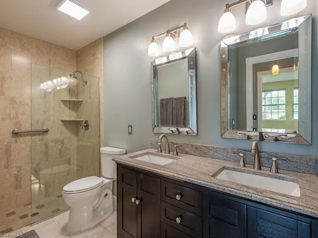 Full bath with walk in shower, double vanity, and light tile patterned floors