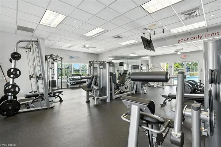 Exercise room with a paneled ceiling and a ceiling fan