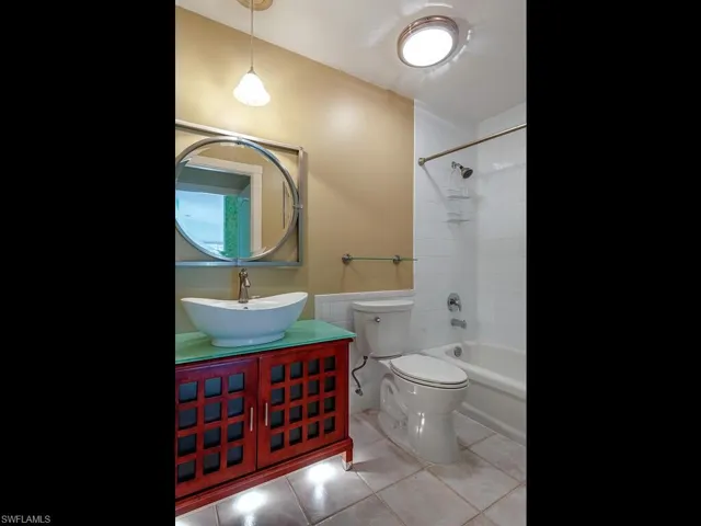 Full bath with tub / shower combination, light tile patterned floors, and vanity