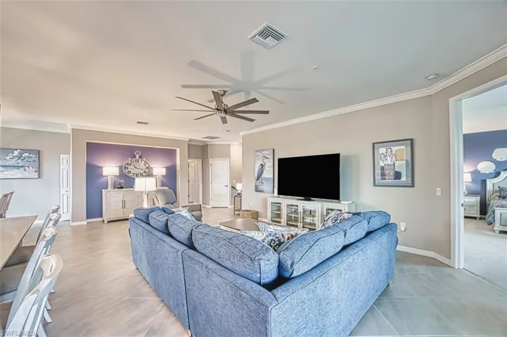 Living area featuring crown molding and ceiling fan