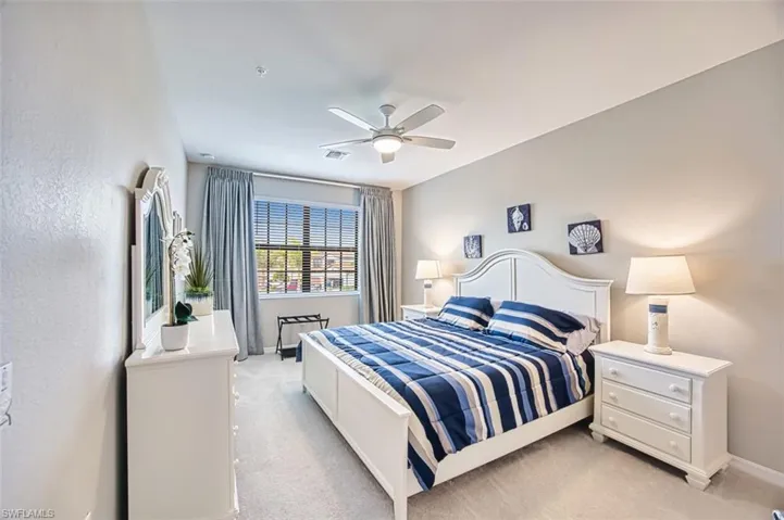 Bedroom #2 with light colored carpet and a ceiling fan