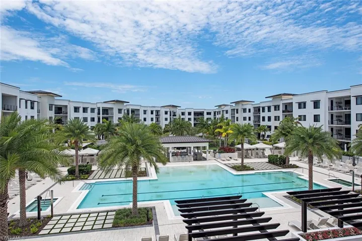 Kitchen featuring coffered ceiling, light hardwood / wood floors, stainless steel appliances, white cabinetry, and an island with sink