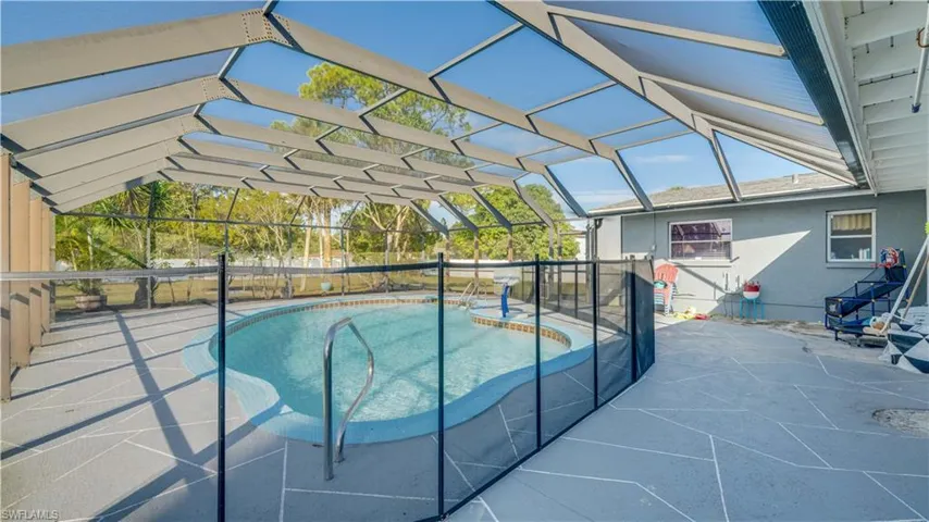 View of pool featuring a patio area, glass enclosure, and a sunroom