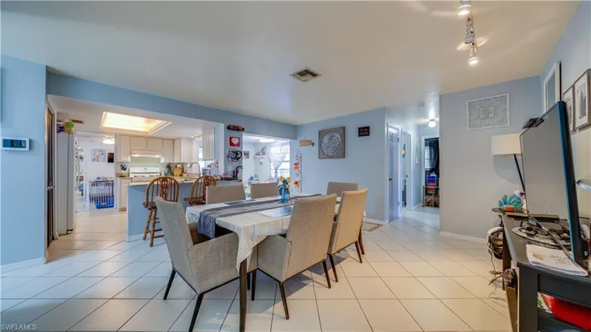 Dining space featuring light tile patterned flooring and rail lighting