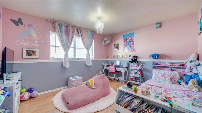Bedroom featuring a chandelier and wood finished floors