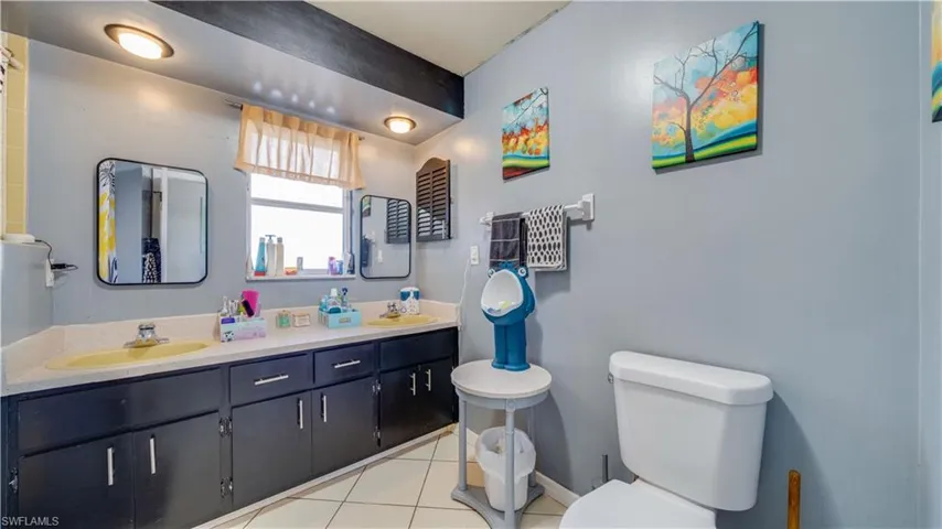 Bathroom featuring double vanity and light tile patterned floors