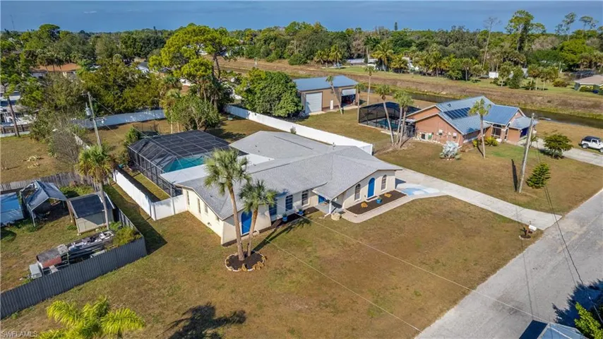 Aerial view of property and surrounding area featuring a tree filled landscape