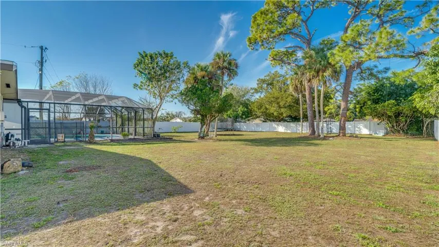 Fenced backyard featuring a sunroom, a lanai, and a swimming pool