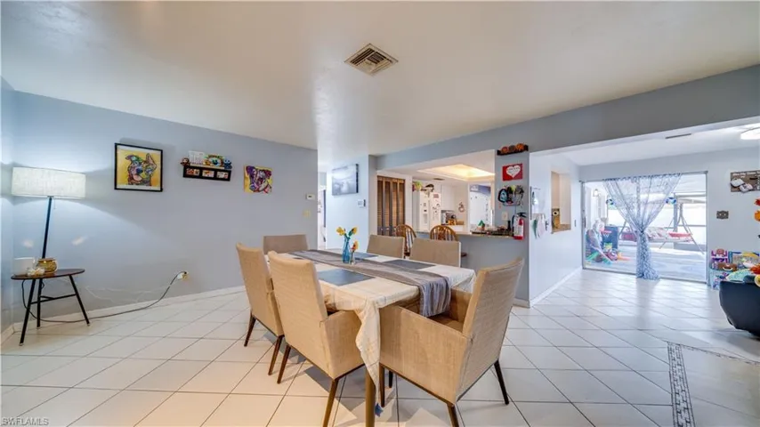 Dining space with light tile patterned flooring and baseboards