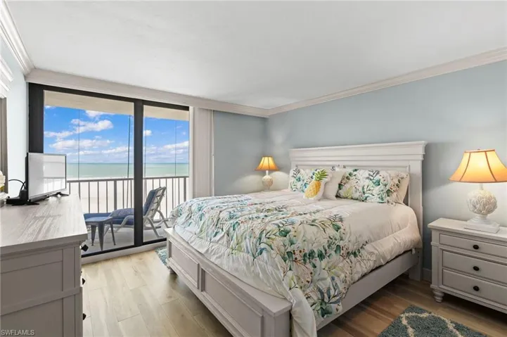 Bedroom featuring access to outside, light wood-type flooring, and crown molding