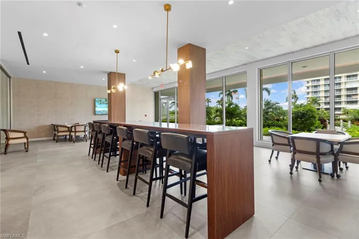 Bar featuring light tile patterned flooring, hanging light fixtures, and a chandelier