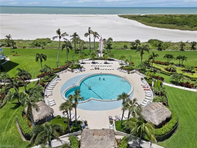 View of pool with a lawn, a patio area, and a water view