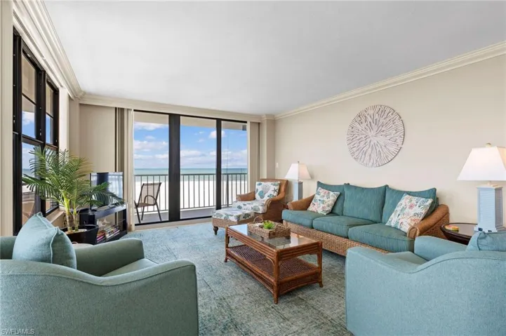 Living room featuring ornamental molding, a water view, and floor to ceiling windows