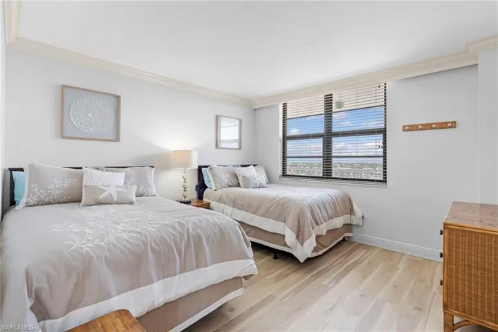 Bedroom with light wood-type flooring and ornamental molding