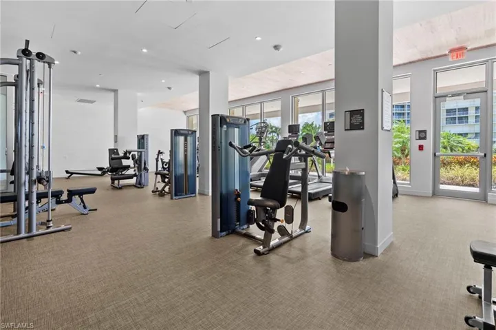 Gym featuring light carpet, wooden ceiling, and a wealth of natural light