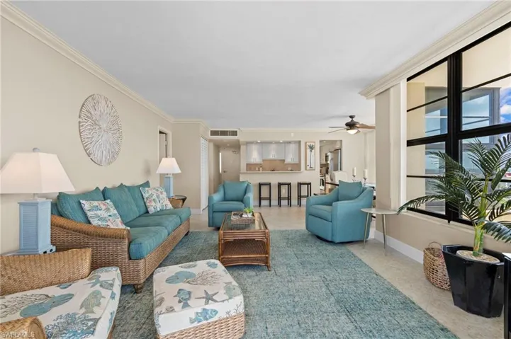 Living room with ornamental molding and ceiling fan