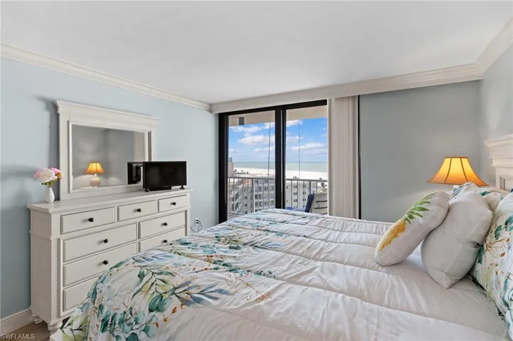 Bedroom featuring a wall of windows, access to outside, and crown molding