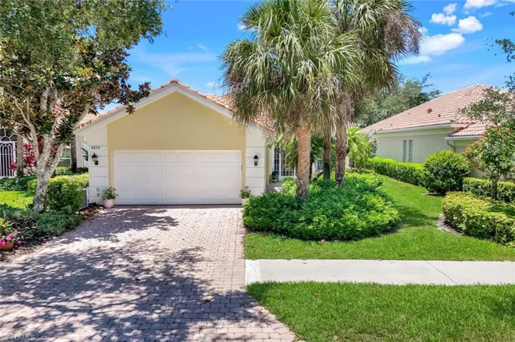 View of front of house with a garage, decorative driveway, stucco siding, and a front lawn