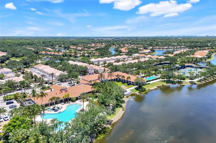 Aerial view of property and surrounding area with a pool area and a nearby body of water