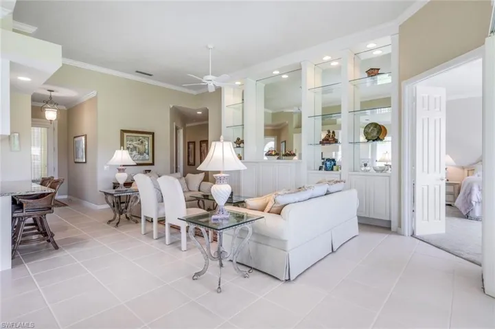 Living area with ornamental molding, light tile patterned flooring, a ceiling fan, recessed lighting, and baseboards