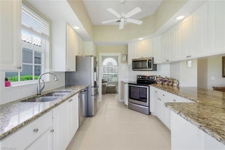 Kitchen featuring appliances with stainless steel finishes, a sink, white cabinets, tasteful backsplash, and recessed lighting