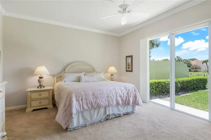 Bedroom featuring light colored carpet, access to exterior, crown molding, baseboards, and ceiling fan