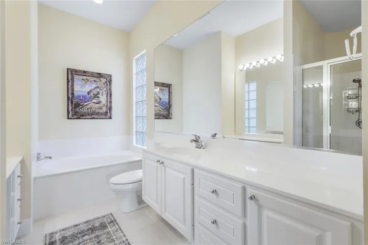 Bathroom with a shower stall, vanity, plenty of natural light, and tile patterned floors