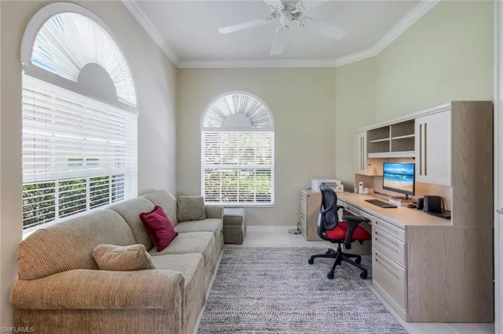 Office space featuring light tile patterned flooring, crown molding, built in study area, and a ceiling fan