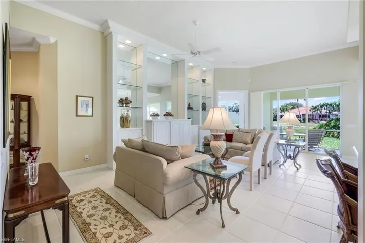 Living area with ceiling fan, crown molding, light tile patterned floors, baseboards, and recessed lighting