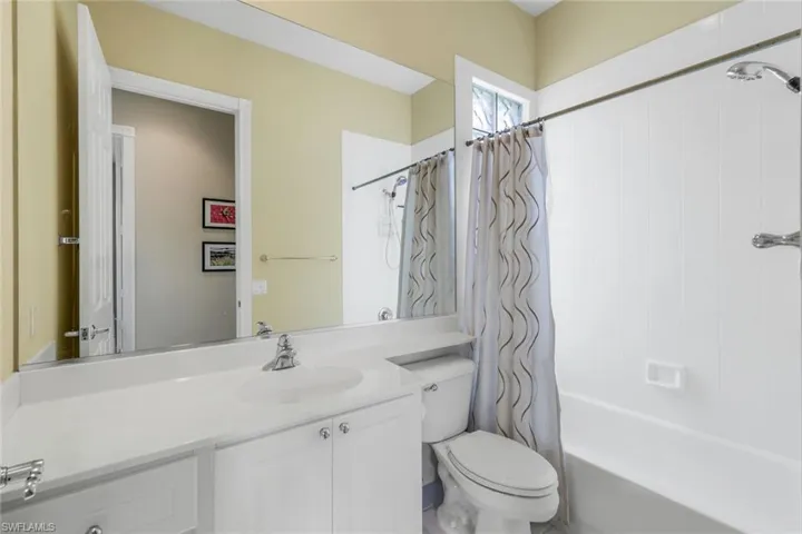 Full bathroom with toilet, vanity, and shower / tub combo with curtain