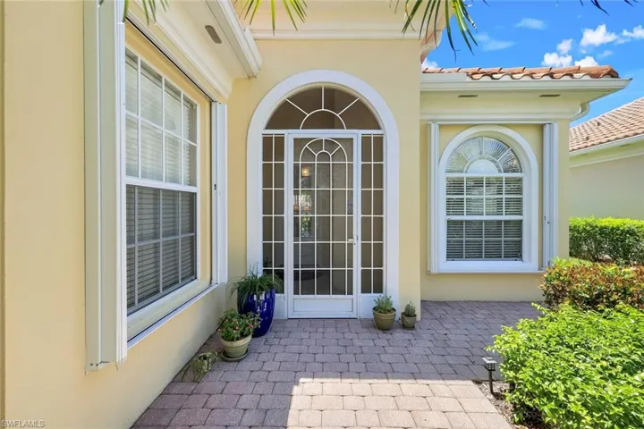 View of exterior entry with stucco siding and a patio
