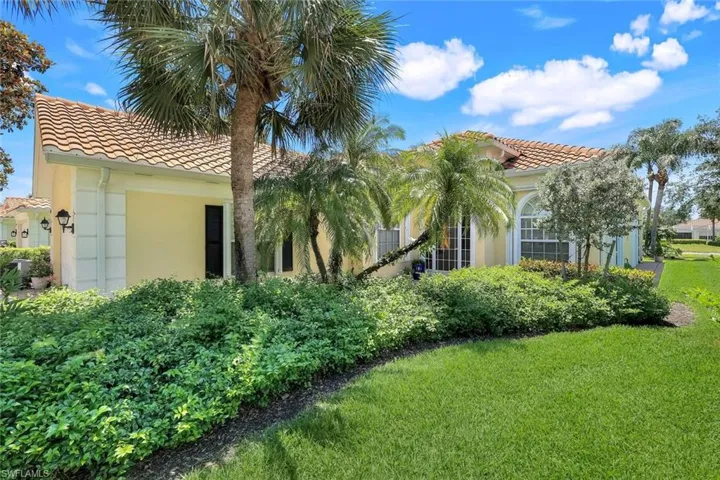 View of front of property featuring a tile roof, stucco siding, and a front lawn